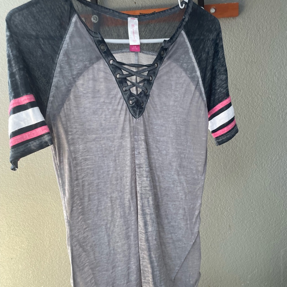 Gray baseball looking shirt with white and pink stripes .